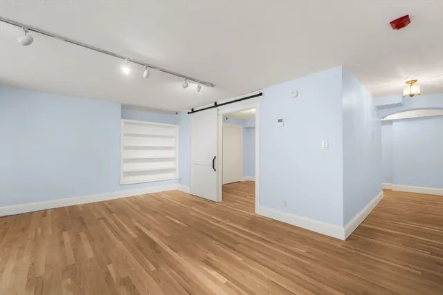 a view of empty room with wooden floor