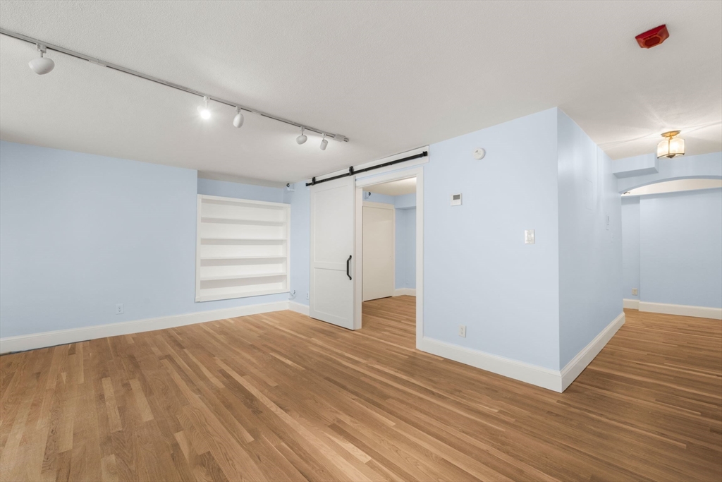 242 Beacon Street, Unit 1 Boston, MA 02116 - Photo 7 of 29 a view of empty room with wooden floor and fan
