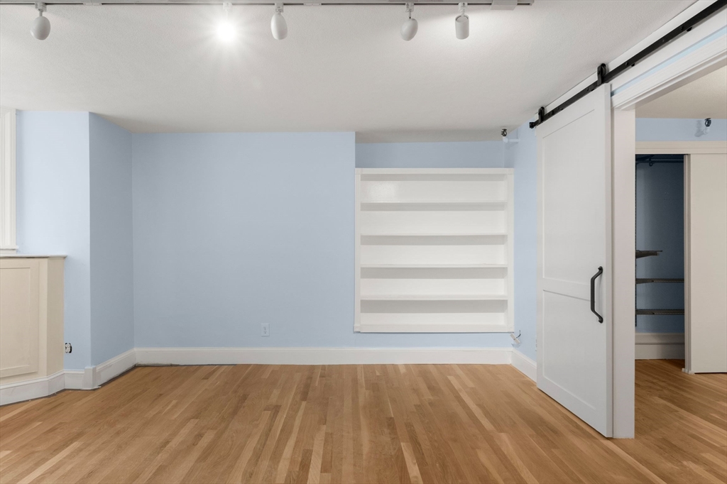 242 Beacon Street, Unit 1 Boston, MA 02116 - Photo 8 of 29 a view of an empty room with wooden floor and a window