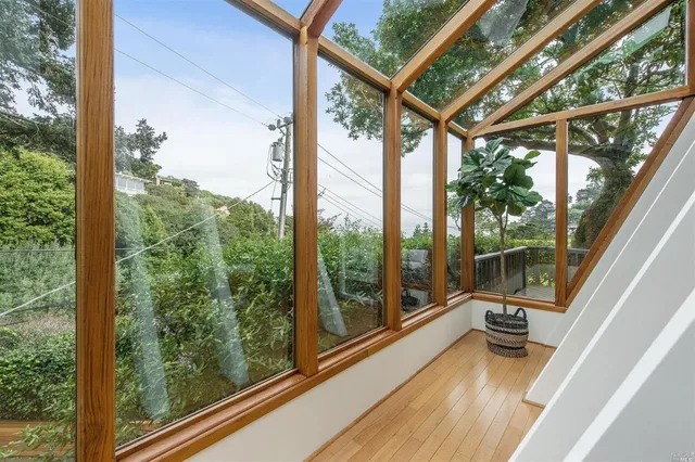 a view of a balcony with floor to ceiling windows with wooden floor