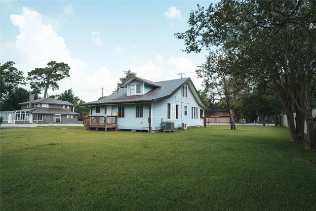 a view of a house with a big yard and large trees