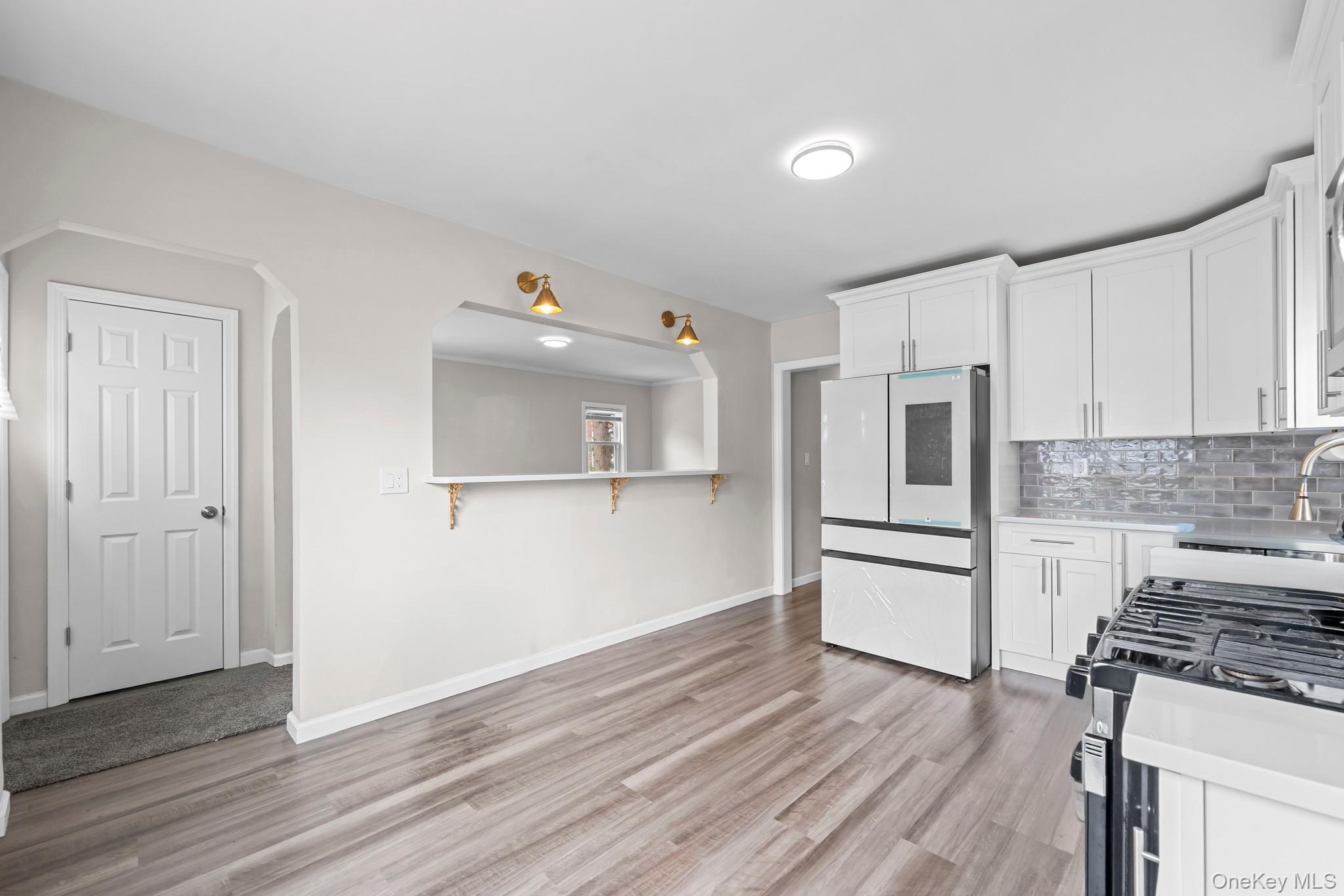 20 Dewitt Street Valley Stream, NY 11580 - Photo 4 of 13 a kitchen with a refrigerator and a stove top oven
