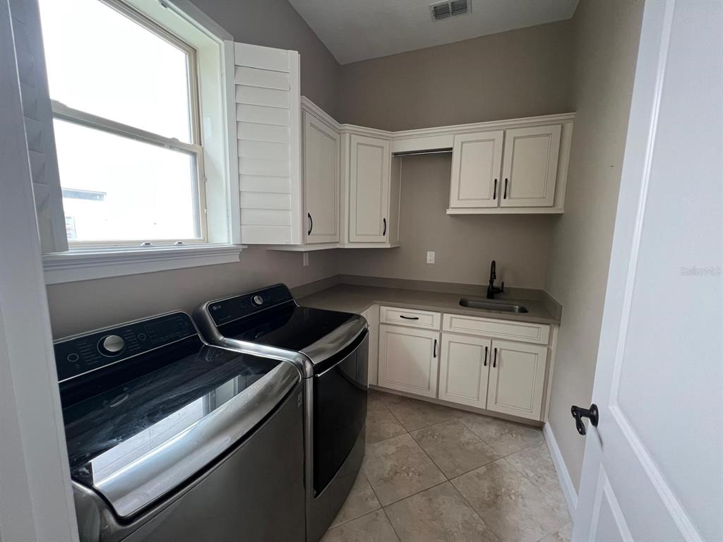 12927 Canopy Woods Way Winter Garden, FL 34787 - Photo 40 of 41 a kitchen with a stove microwave and sink