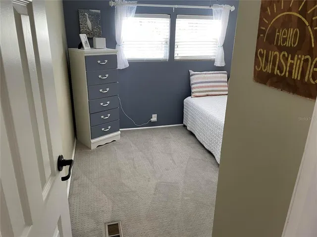 a bedroom with a bed and a flat tv screen on the dresser