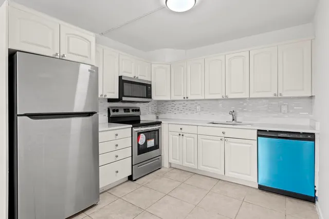 a kitchen with cabinets stainless steel appliances and a sink