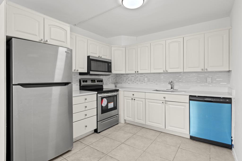 a kitchen with cabinets stainless steel appliances and a sink
