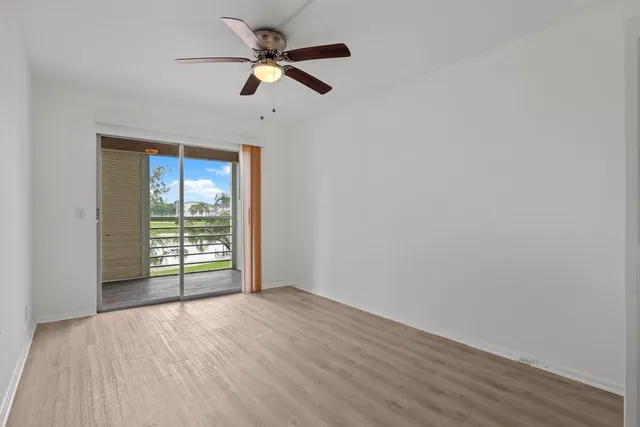 a view of a room with wooden floor and a ceiling fan