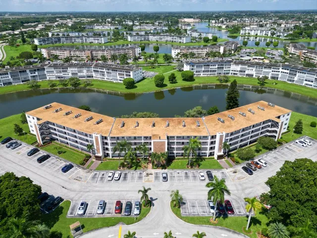 an aerial view of a house with a garden and lake view