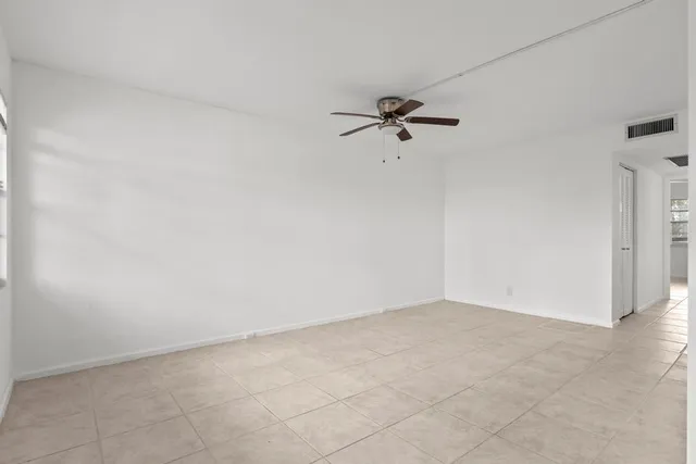 an empty room with fan and entrance