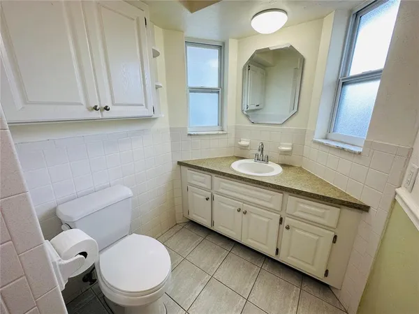 a bathroom with a toilet sink and mirror