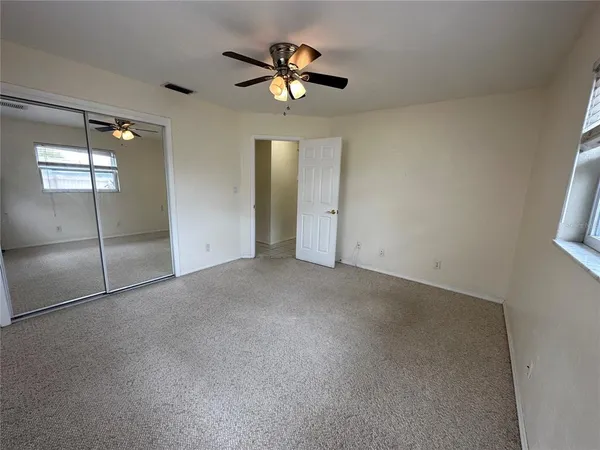 a view of an empty room with a ceiling fan