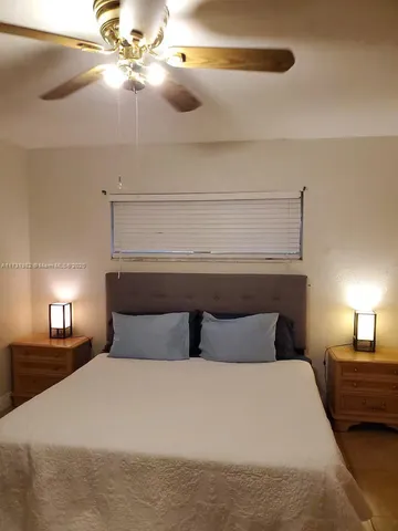 a bedroom with a bed and lamp on desk