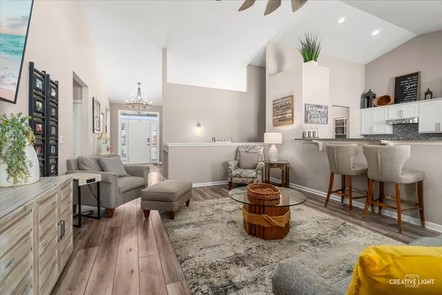 a living room with furniture a flat screen tv and kitchen view