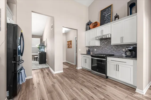 a kitchen with stainless steel appliances granite countertop a refrigerator and a stove top oven