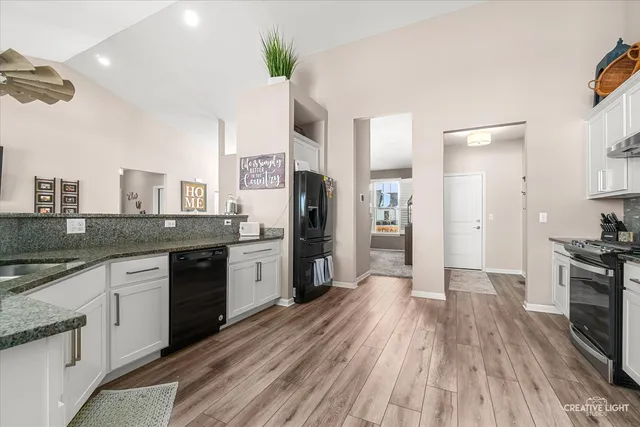 a large kitchen with cabinets wooden floor and stainless steel appliances