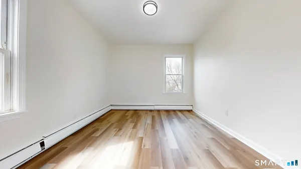 a view of a room with wooden floor and window