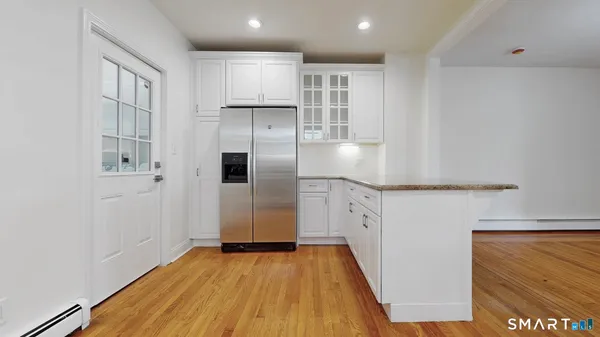 a view of a kitchen with wooden floor and electronic appliances