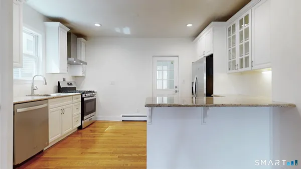 a kitchen with stainless steel appliances granite countertop a sink stove and cabinets