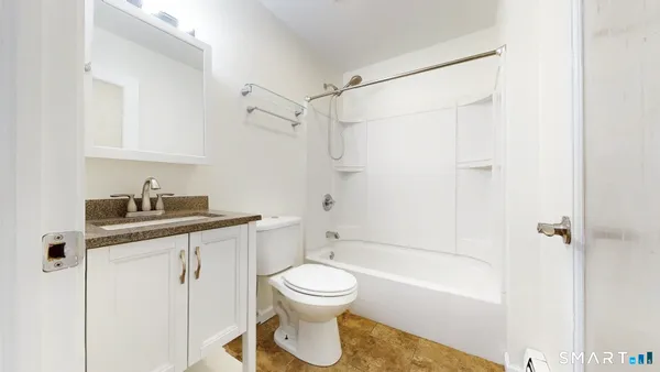a bathroom with a granite countertop sink toilet and shower
