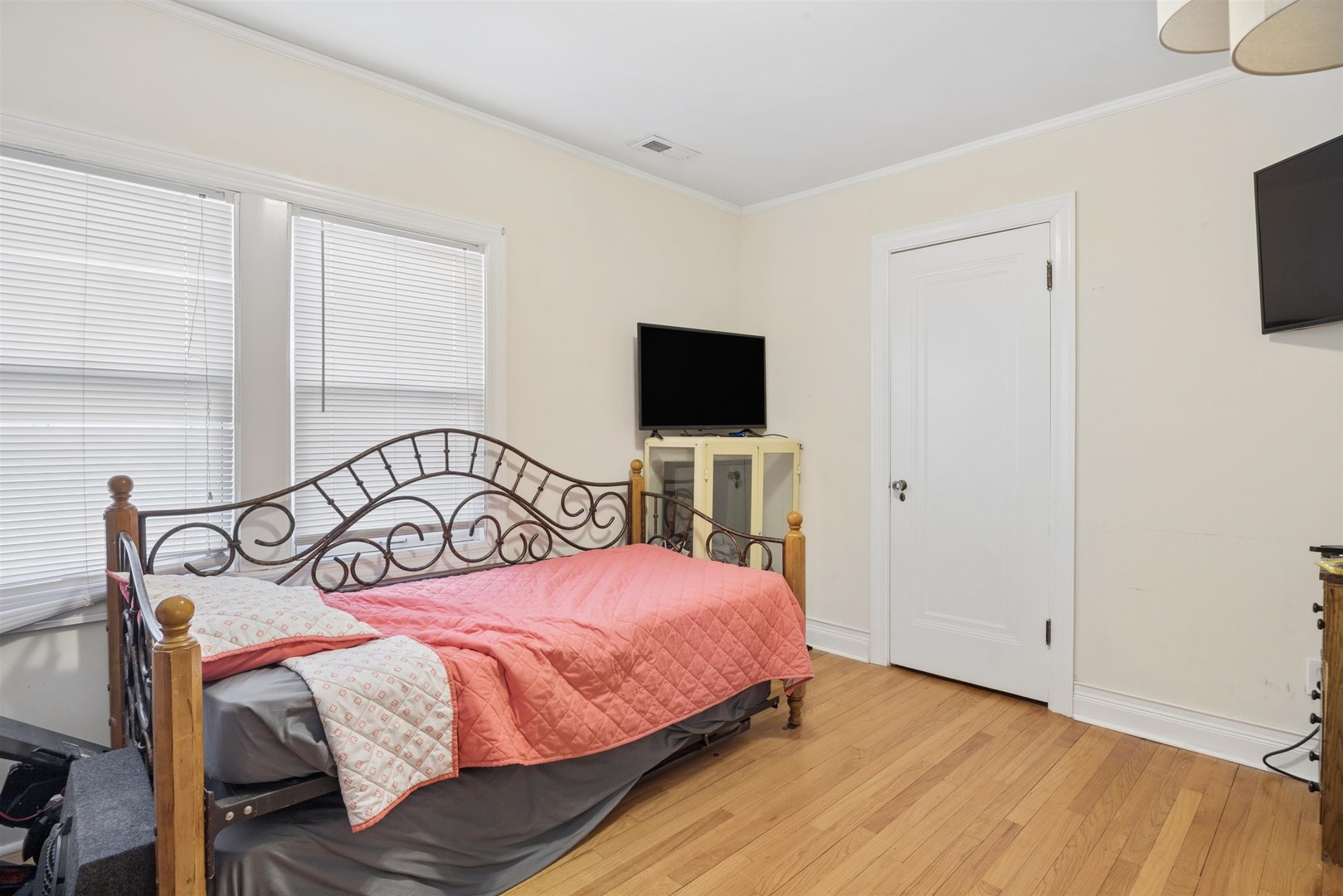1120 Dobson Street Evanston, IL 60202 - Photo 13 of 21 a bedroom with a bed a tv and wooden floor
