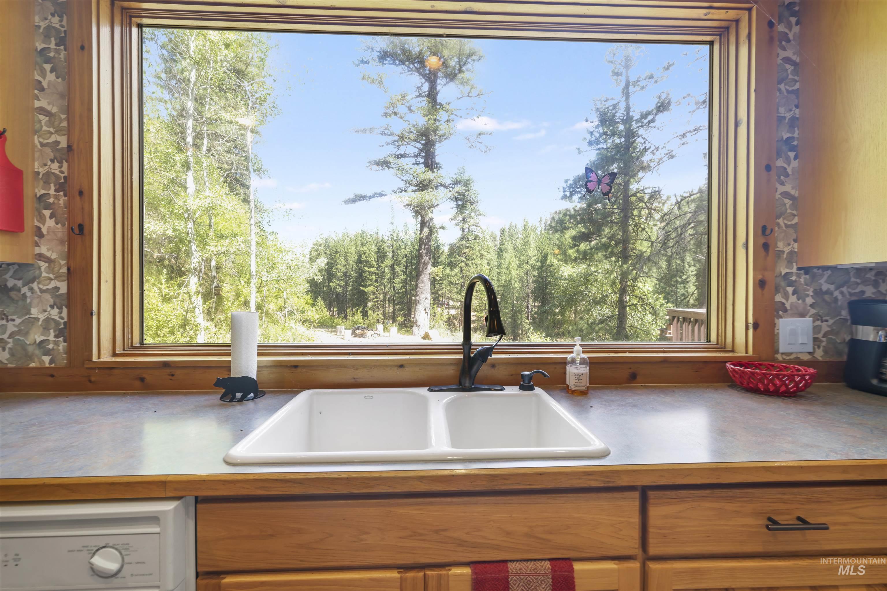 224 Dakota Road Mountain Home, ID 83647 - Photo 10 of 50 Kitchen sink with a dual basin, a high-arc faucet, and wood-finish cabinetry