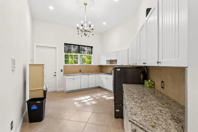 a view of a white house with a yard and plants