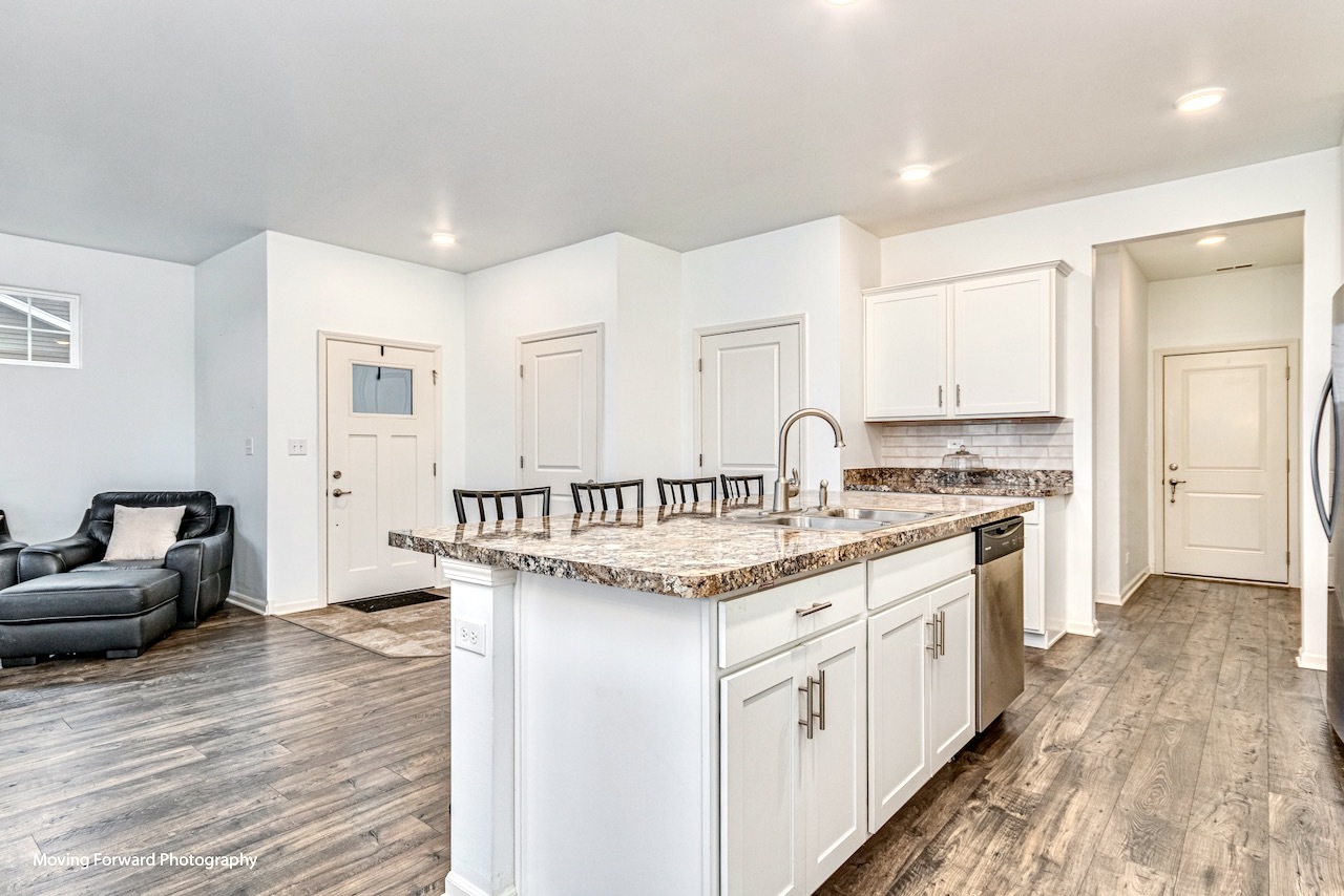 1908 Southern Circle, Unit 1908 Pingree Grove, IL 60140 - Photo 6 of 30 a kitchen that has a lot of white cabinets and wooden floor