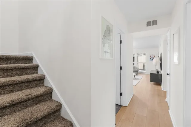 a view of a hallway with wooden floor and staircase