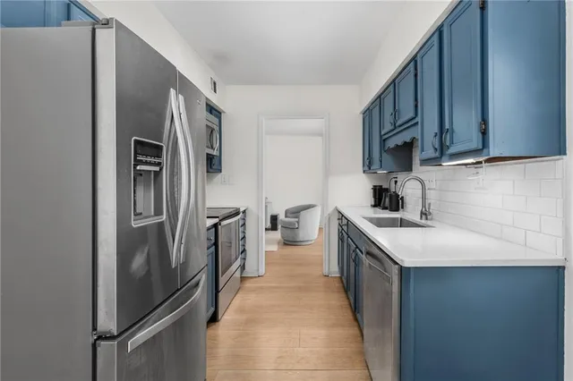a kitchen with a sink and stainless steel appliances