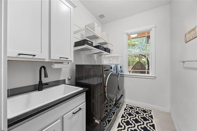a utility room with cabinets washer and dryer