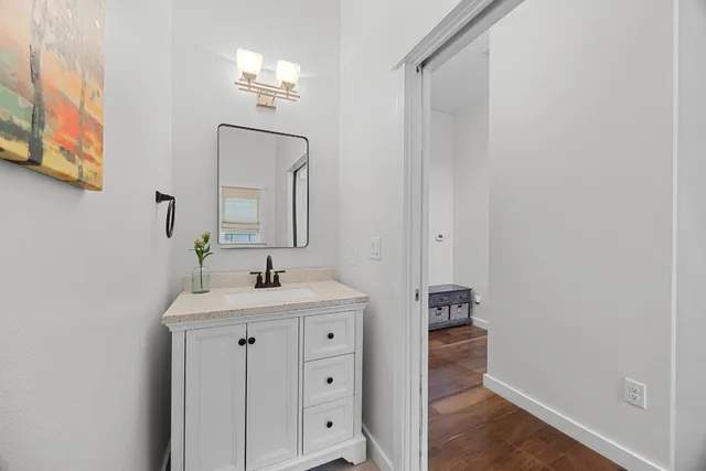 a bathroom with a sink a light fixture and a mirror