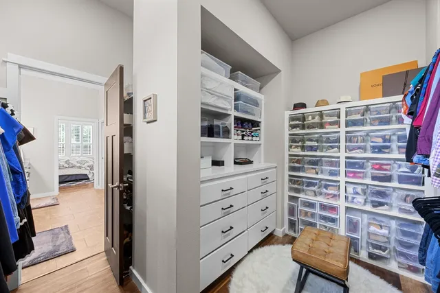 a view of walk in closet with clothes and shoes