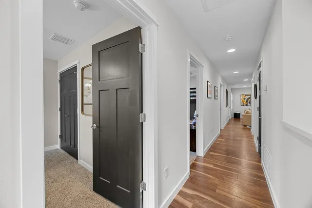 a view of a hallway with wooden floor and staircase