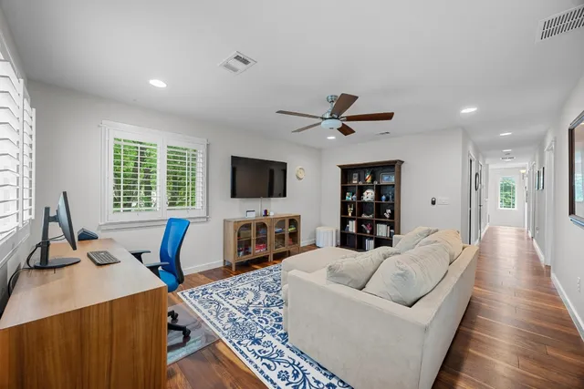 a living room with furniture flat screen tv and a large window