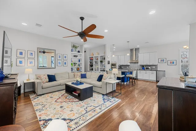 a living room with furniture kitchen view and a window