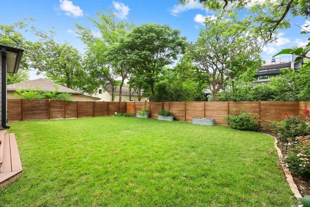 a view of a yard with a fence and trees