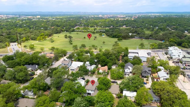 an aerial view of residential houses with outdoor space and trees