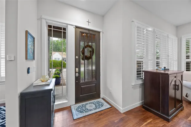 a view of a hallway with wooden floor and windows