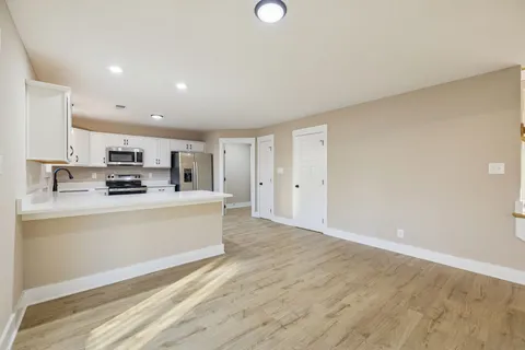 a view of kitchen with wooden floor and electronic appliances
