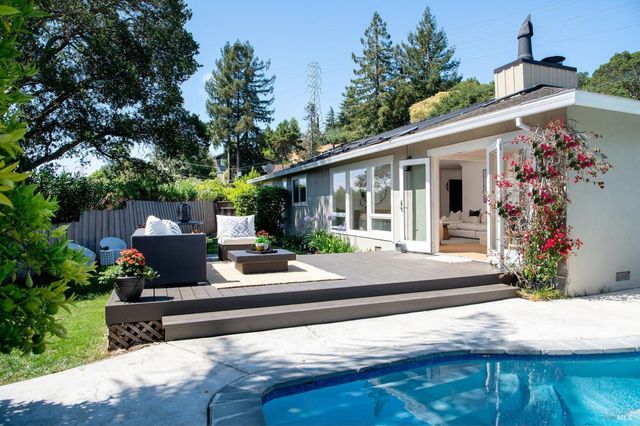 a view of a house with backyard and sitting area