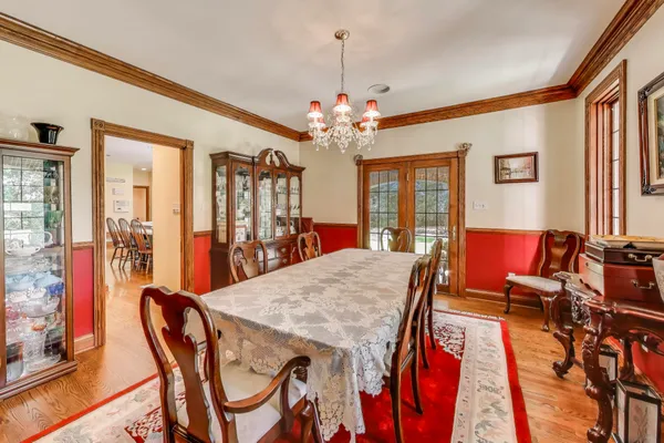a living room with stainless steel appliances granite countertop a couch and a bookshelf with wooden floor