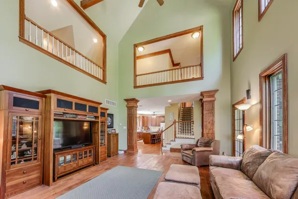 a bedroom with a bed and dresser with wooden floor