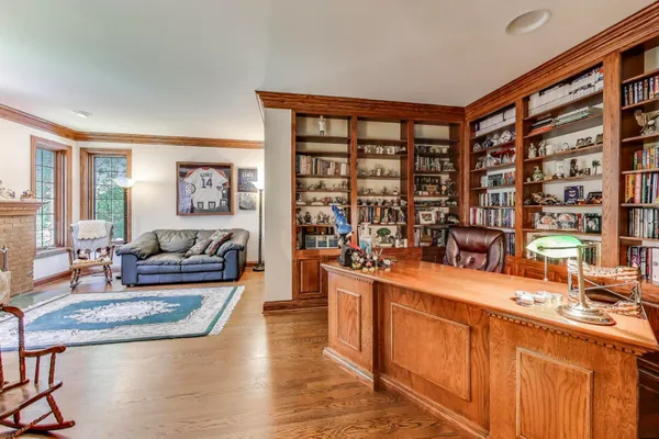 a view of staircase with lots of frames on wall and wooden floor