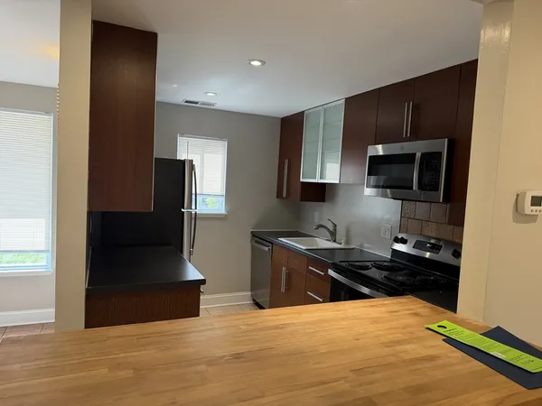 a kitchen with stainless steel appliances kitchen island granite countertop a stove and a refrigerator