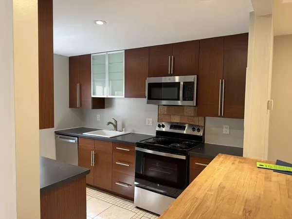 a kitchen with stainless steel appliances wooden cabinets and a stove top oven