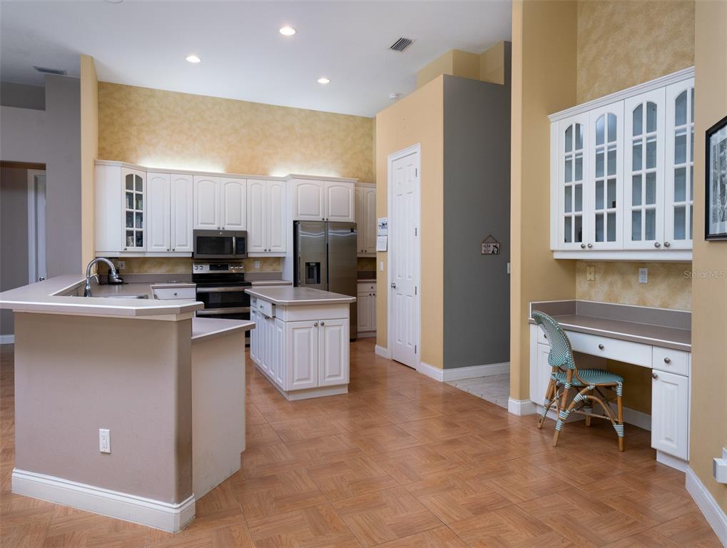 2185 Northwest 114th Loop Ocala, FL 34475 - Photo 6 of 25 a kitchen with microwave a refrigerator and chairs