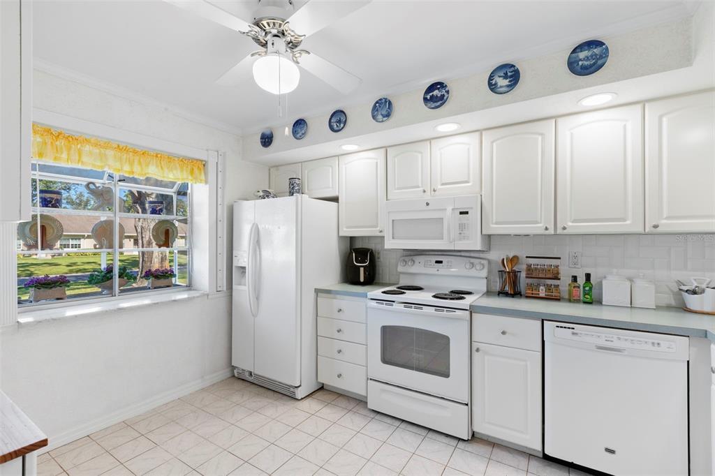 1012 Dunrobin Drive, Unit D Palm Harbor, FL 34684 - Photo 23 of 61 a kitchen with white cabinets and white appliances