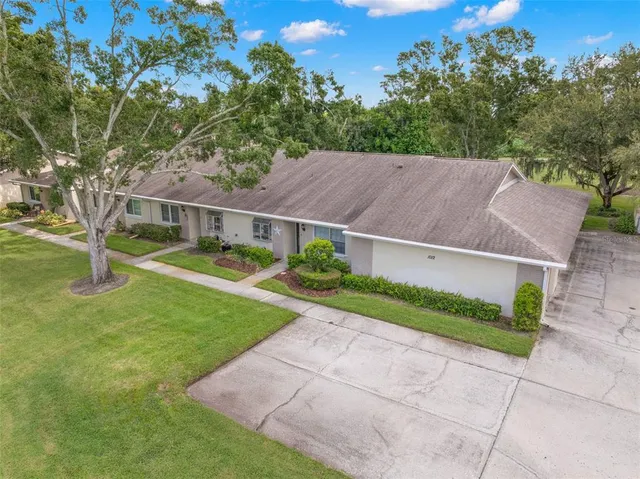 an aerial view of residential houses with outdoor space and trees