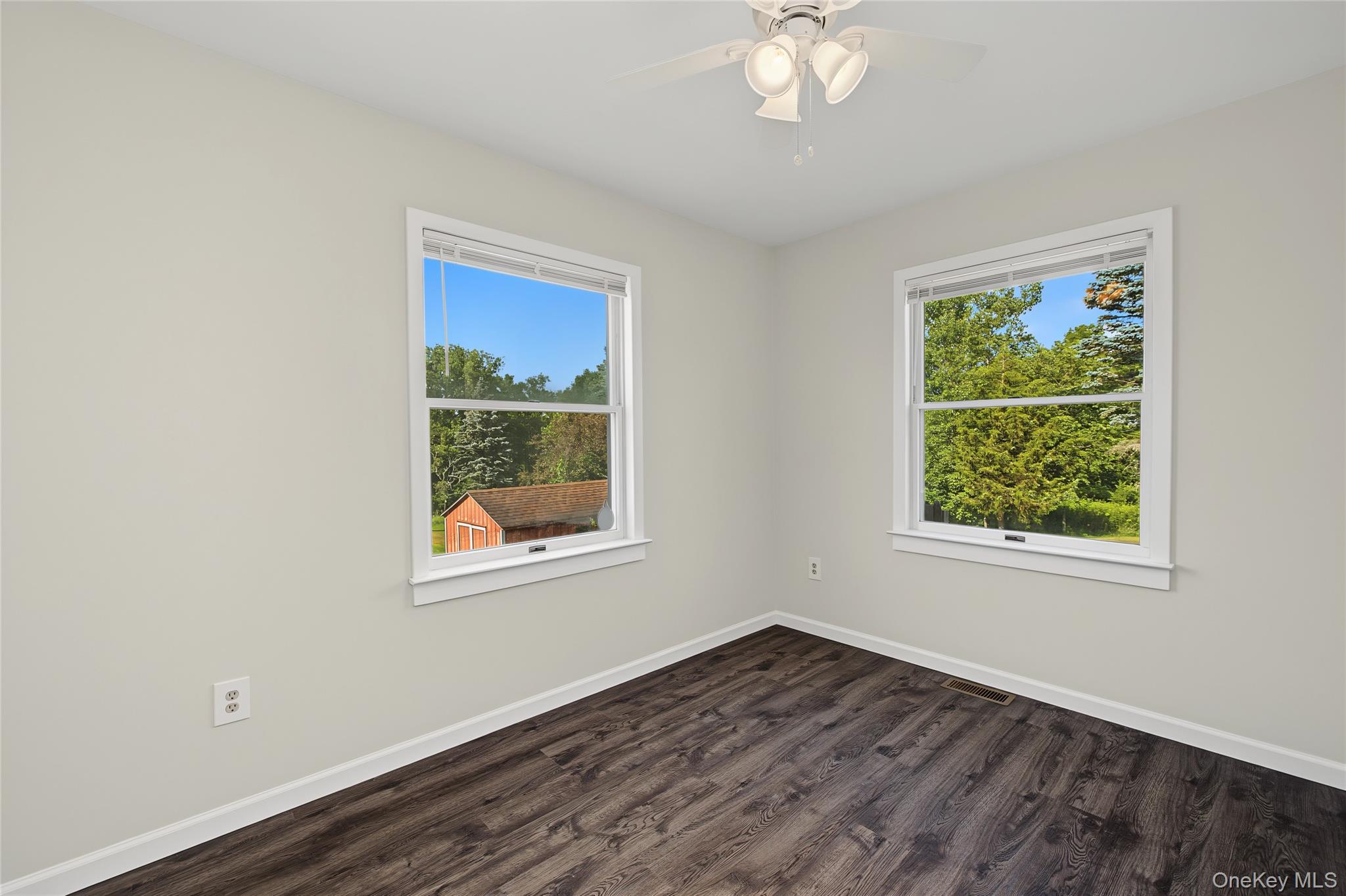 318 Cornwall Hill Road Patterson, NY 12563 - Photo 8 of 38 Bright room featuring two windows, wood-finish flooring, white baseboards, and a ceiling fan with integrated lighting