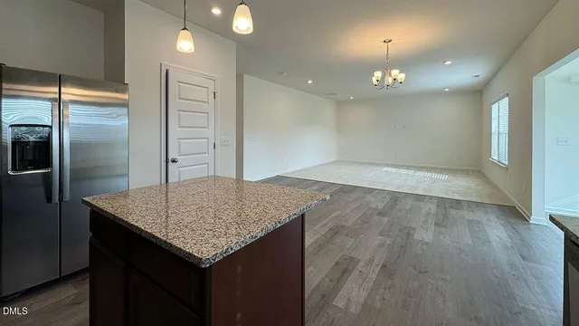 a kitchen with stainless steel appliances granite countertop a sink stove microwave and refrigerator